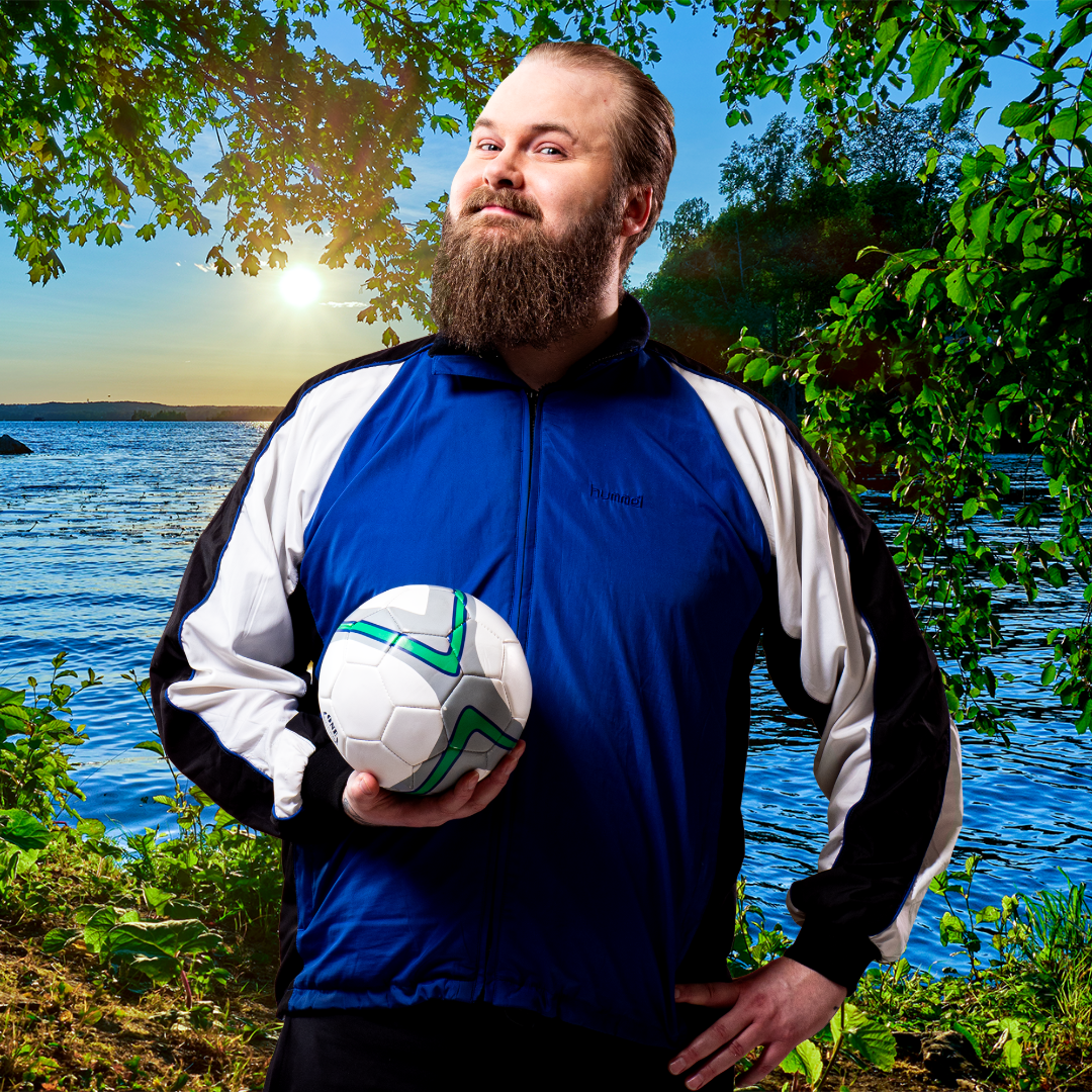 näyytelijä poseeraa pallon kanssa kesäisessä auringonlaskumaisemassa järven rannalla